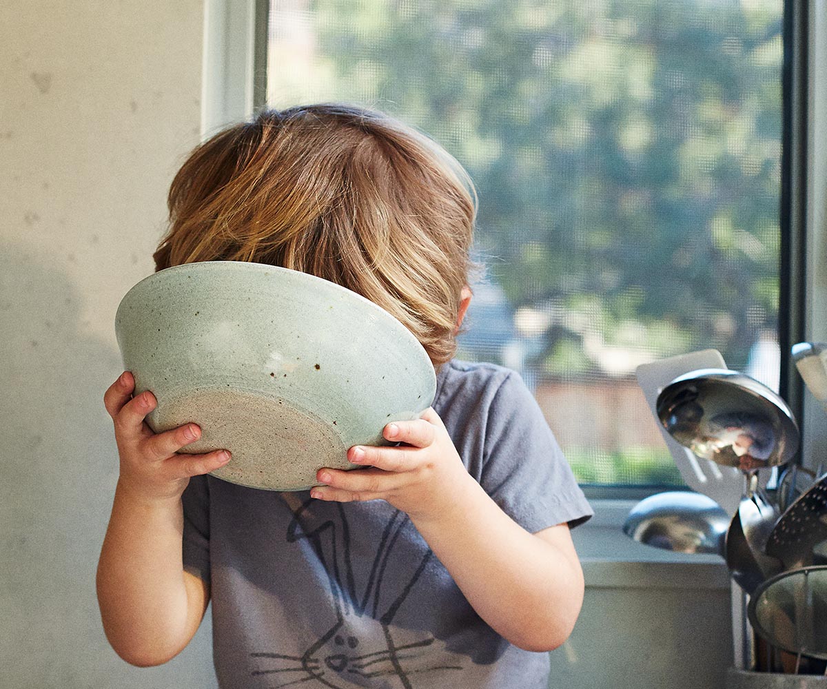 Child drinking milk from a bowl