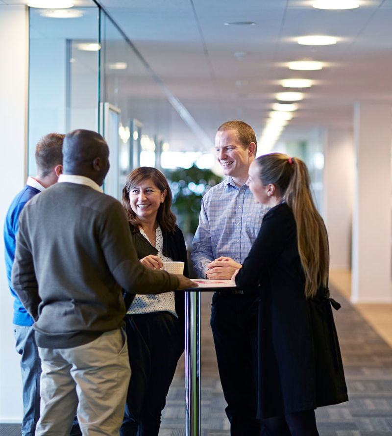 5 people at a standup meeting in an office