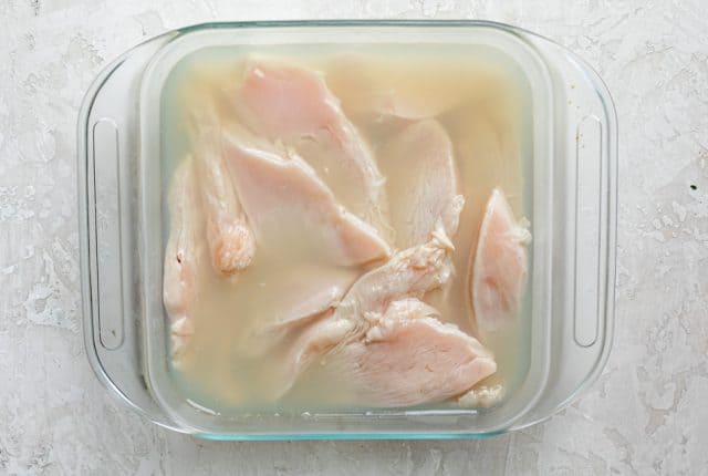 Chicken tenders brining in pickle juice