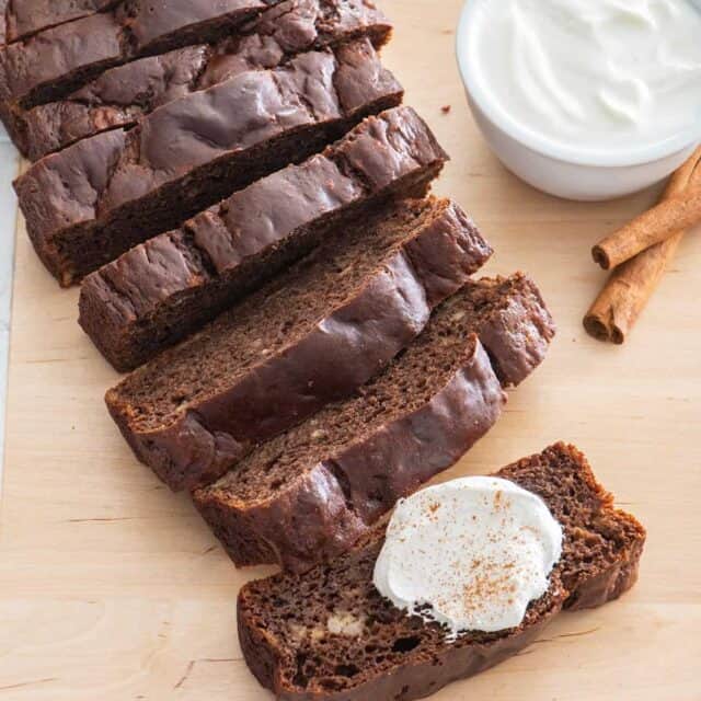 Chocolate cinnamon banana bread with dollop of greek yogurt and cinnamon sticks