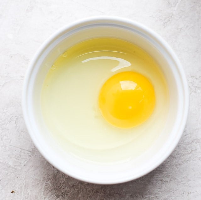 One egg in ramekin before poaching
