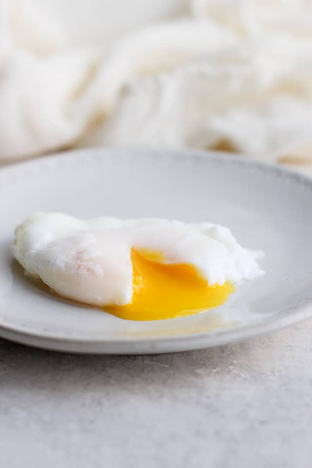 Runny poached egg on a plate