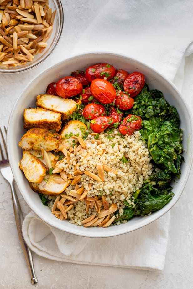 Large chicken and quinoa bowl with vegetables on top