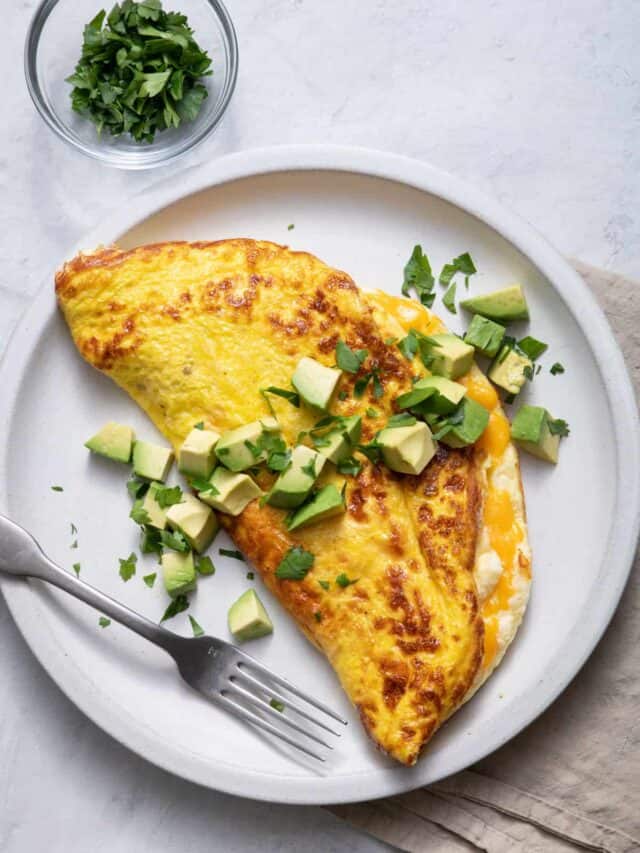 Large plate of souffle omelette topped with avocados and parsley