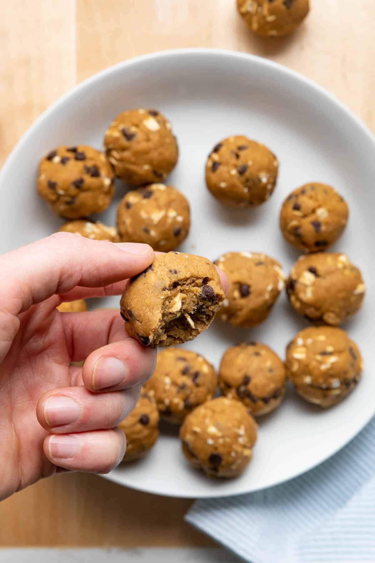Hand holding one of the pumpkin balls with bite taken out of it