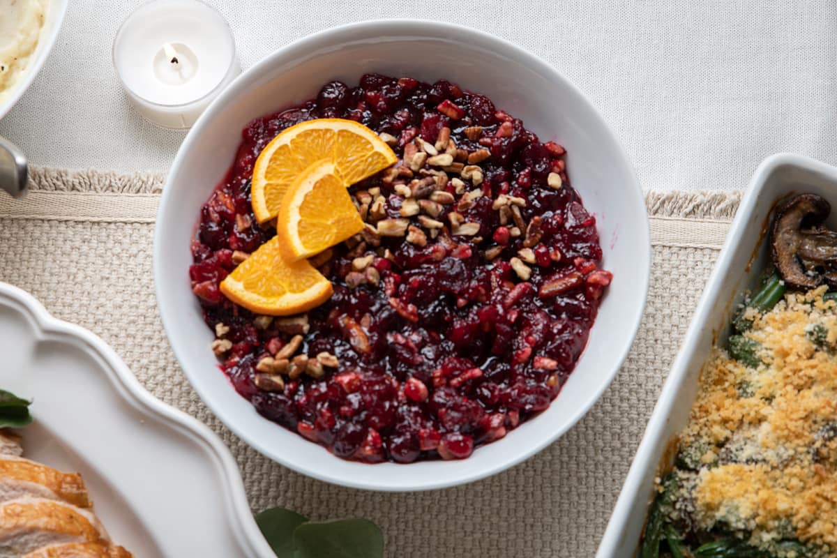 Baked cranberry relish on thanksgiving dinner table next to turkey and green beans