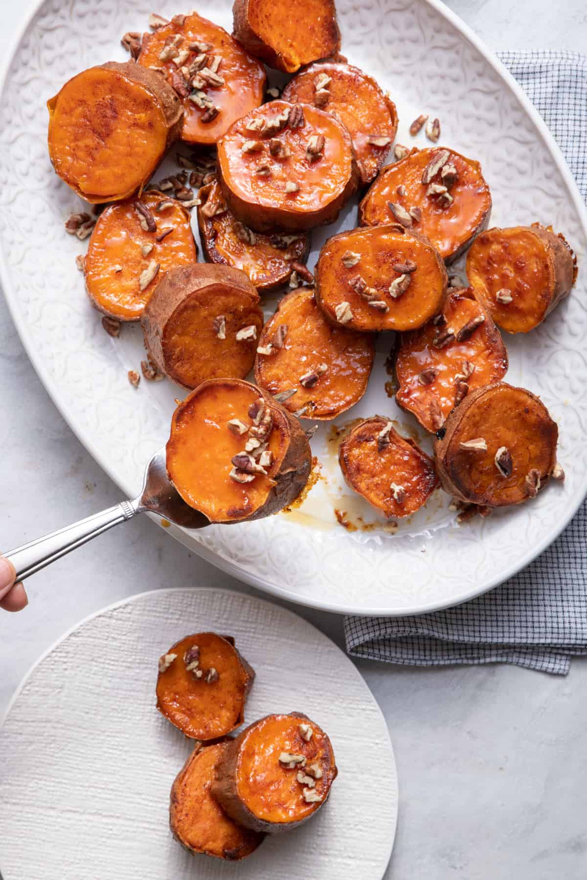 Serving spoon serving the melting sweet potatoes to a small plate