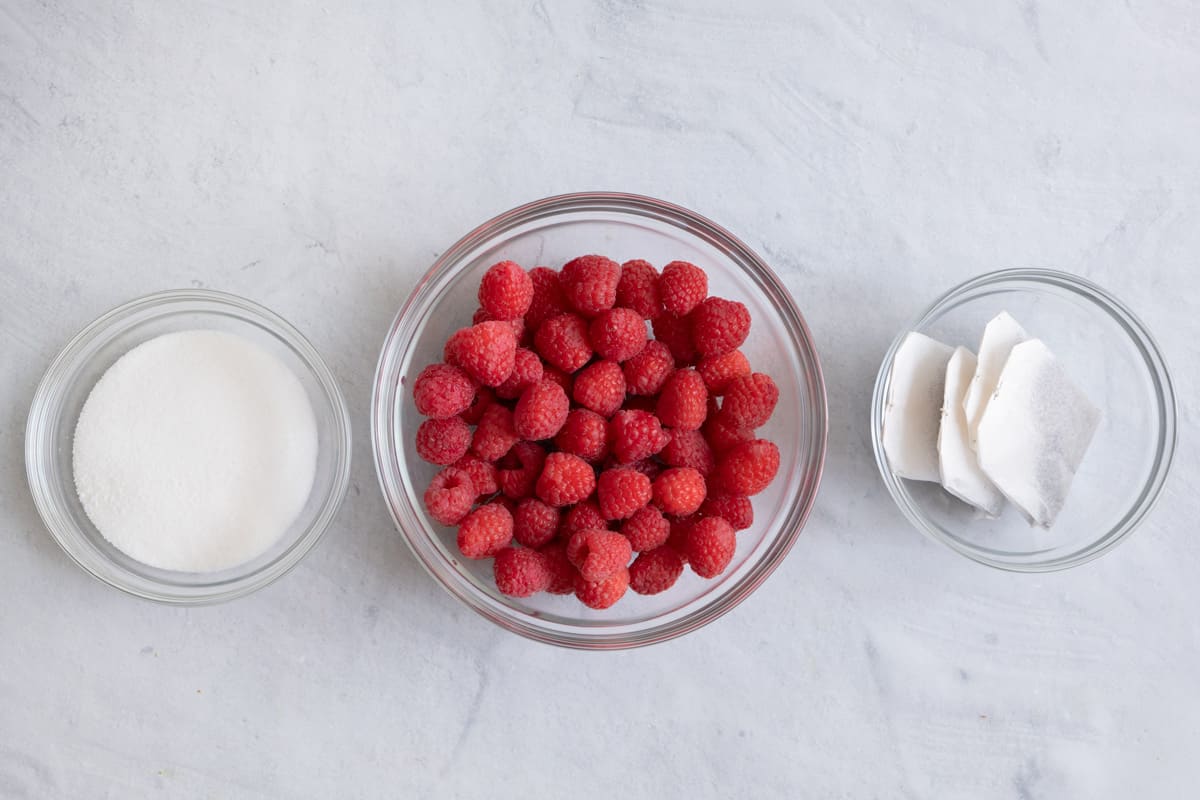 Ingredients for iced tea recipe: sugar, fresh raspberries, and 4 tea bags.