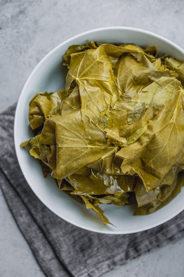 The making of Vegetarian Stuffed Grape Leaves - the grape leaves washed from the brine sitting in a large bowl