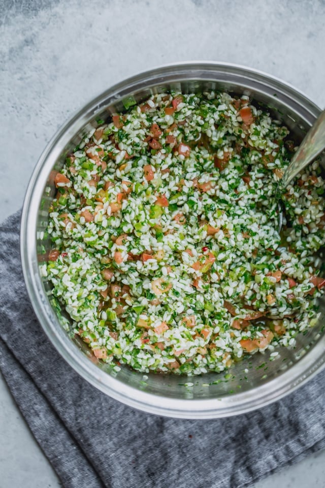 Ingredients for Vegetarian Stuffed Grape Leaves - Large bowl mixture of rice, parsley, tomatoes, green onions, green peppers, garlic and crushed red pepper.