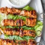Shish tawook recipe on a platter with garlic sauce