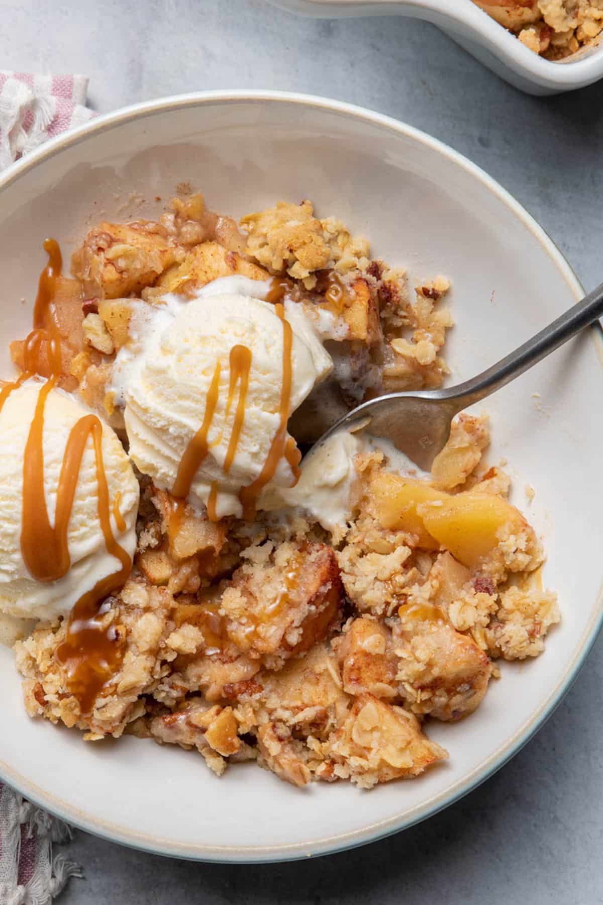 the crisp with ice cream and caramel sauce on top and spoon digging in