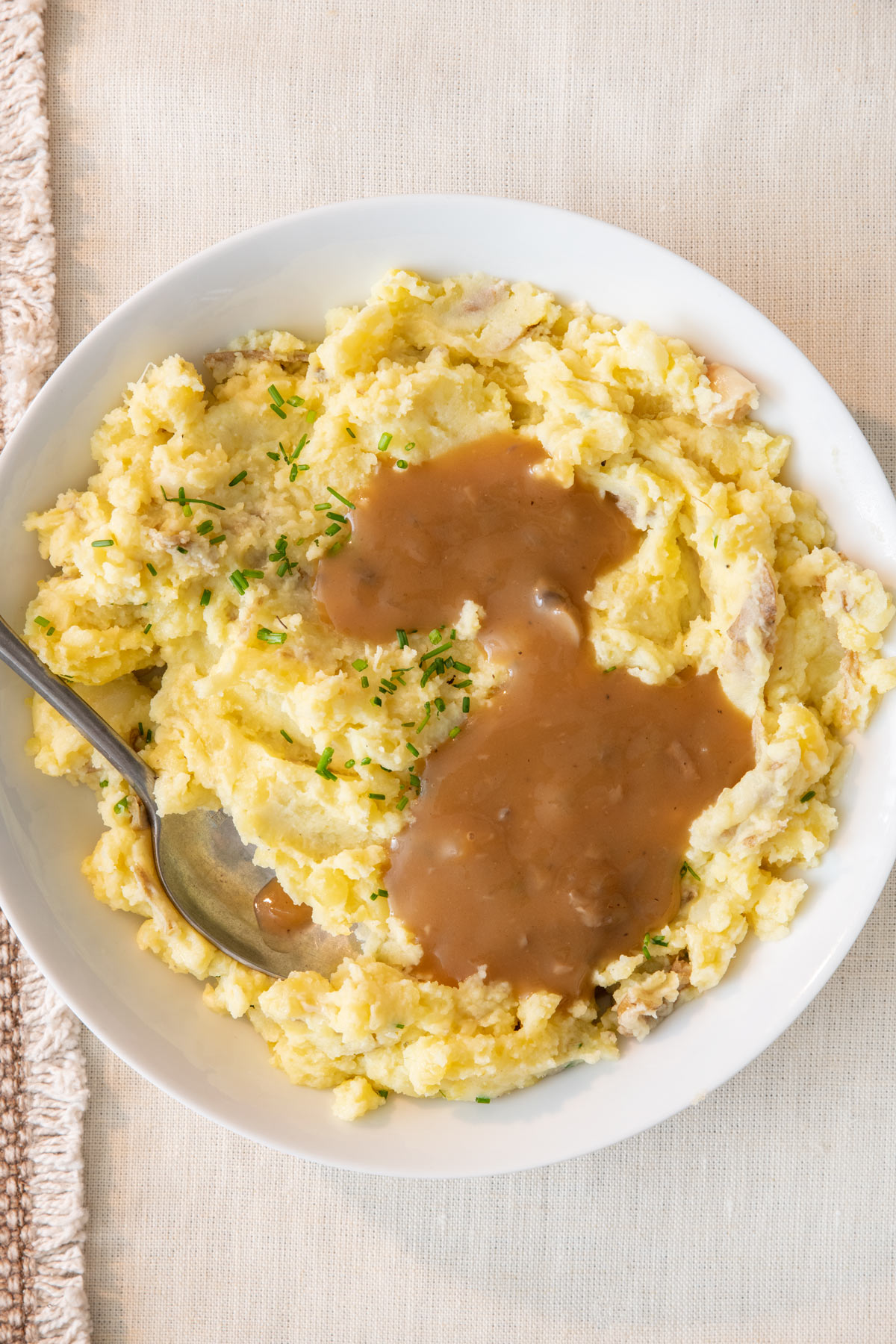 Bowl of mashed potatoes topped with vegan mushroom gravy.