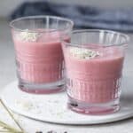 Two glasses of aloe vera smoothie topped with shredded coconut