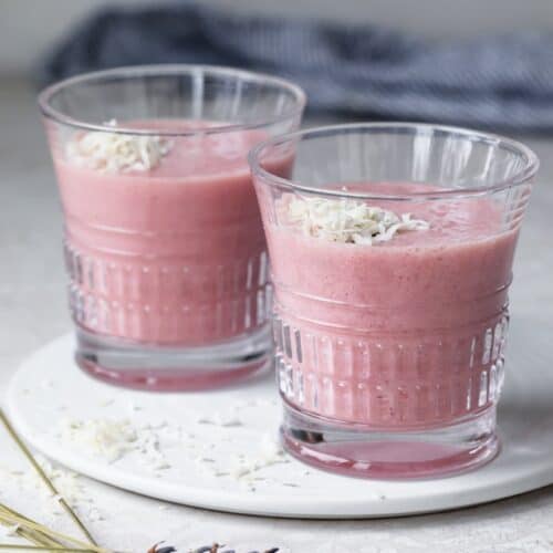 Two glasses of aloe vera smoothie topped with shredded coconut