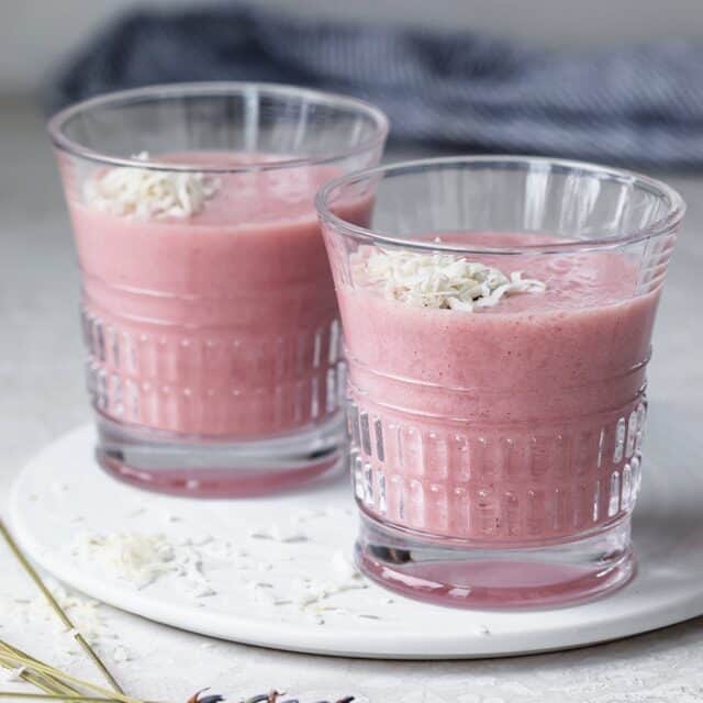 Two glasses of aloe vera smoothie topped with shredded coconut