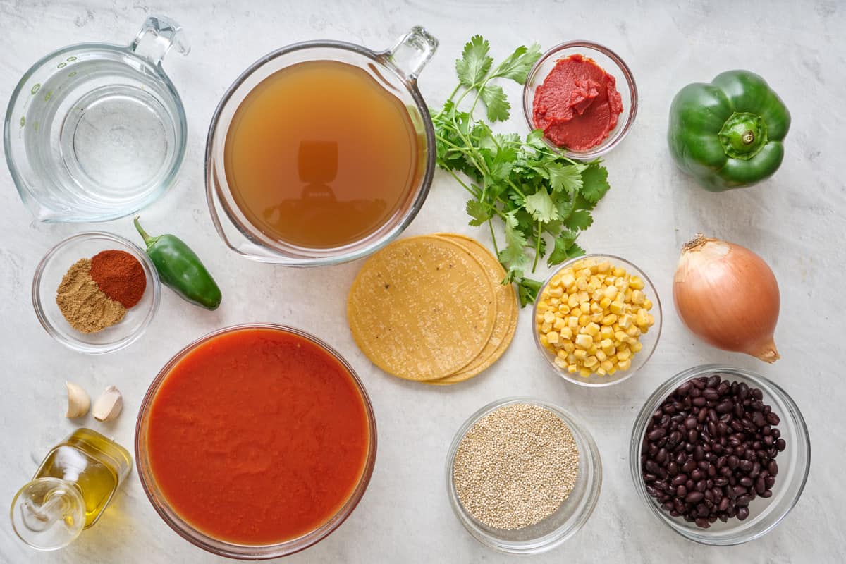 Ingredients for recipe before prepping: oil, onion, bell pepper, jalapeno, garlic, tomato paste, spices, vegetable broth, water, crushed tomatoes, cilantro, quinoa, black beans, corn.