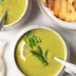 Close up of cream of asparagus soup in bowl with spoon