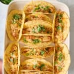 Baked chicken tacos in baking pan.
