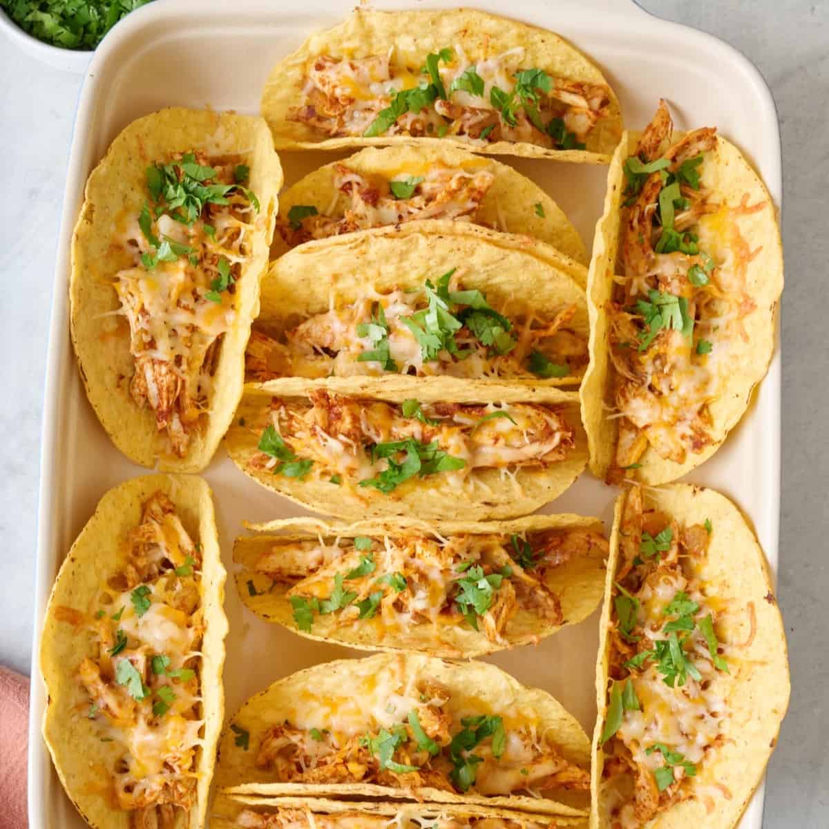 Baked chicken tacos in baking pan.