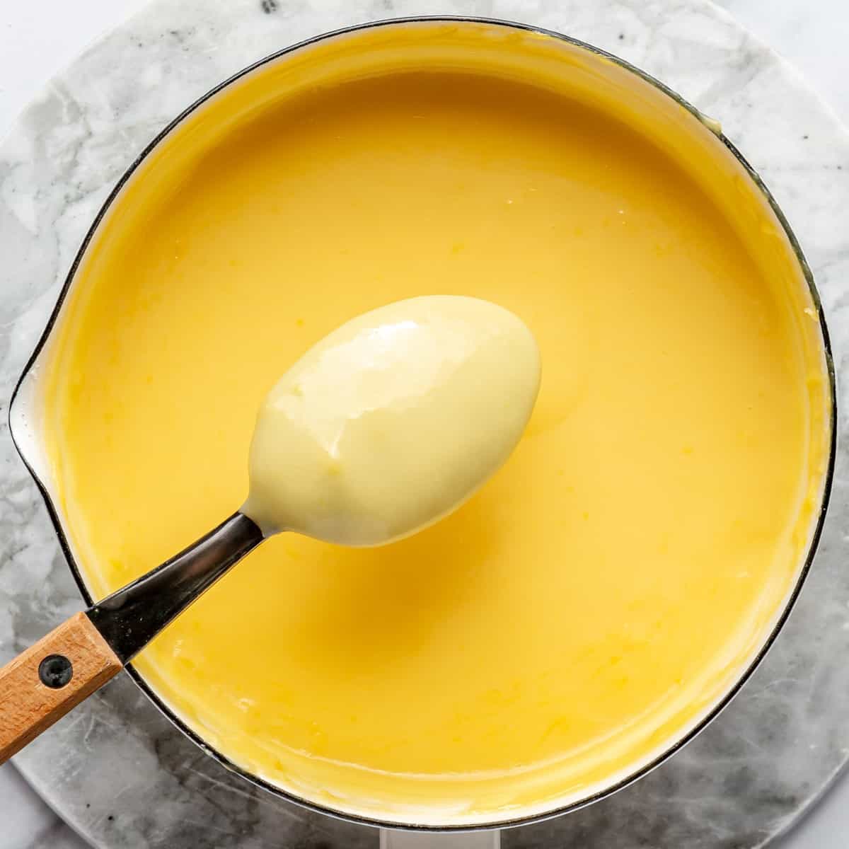 Pudding after cooking with some on the back of a spoon to show thickness.