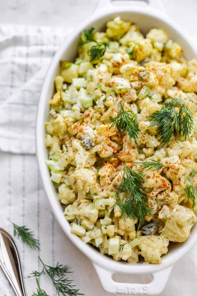 Final cauliflower potato salad garnished with dill and paprika