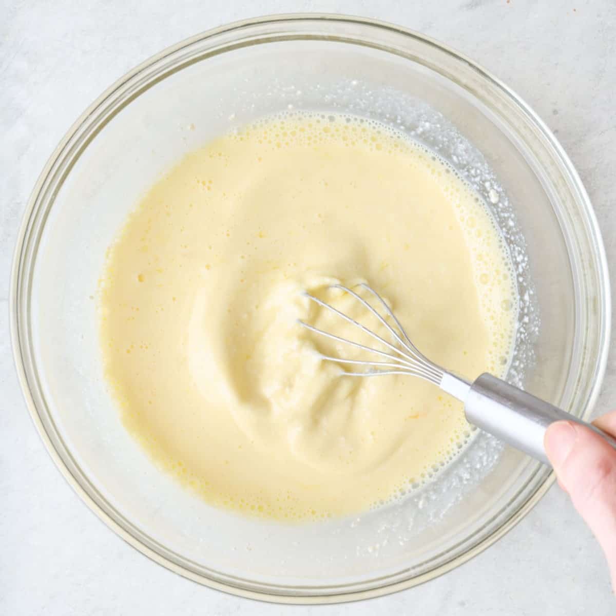 Whisking wet ingredients in a bowl.