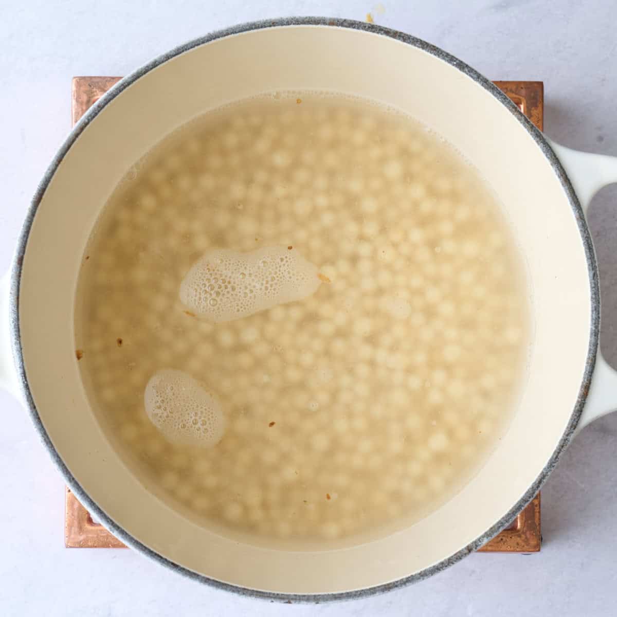 Couscous in a pot of water before cooking.