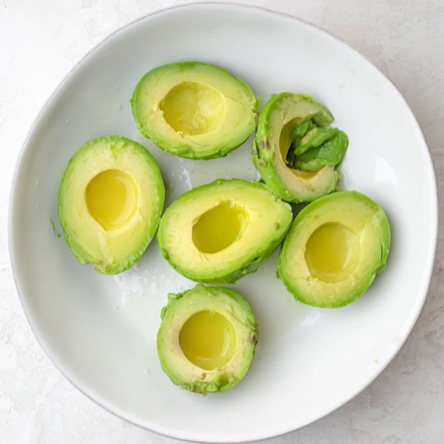 Avocados in a large bowl before mashing.
