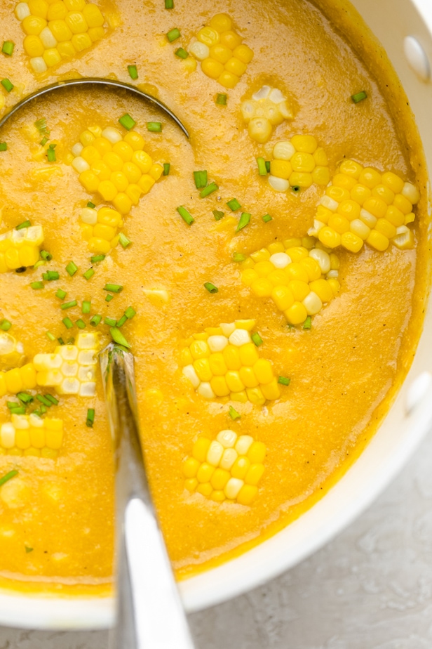 overhead shot of vegan corn chowder in a white bowl