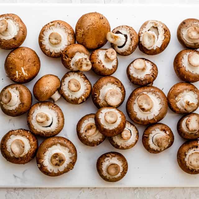 Mushrooms on cutting board before cutting.