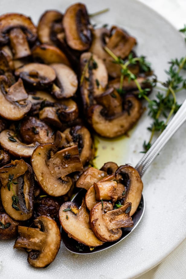 Close up of the mushrooms being spooned into large servingspoon