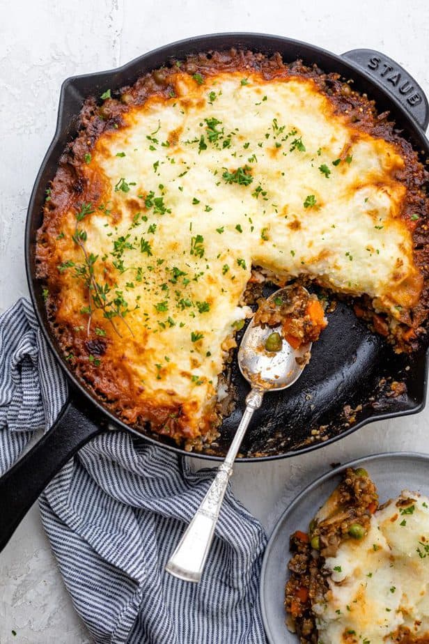 Spooning serving of the vegetarian shepards pie into a plate
