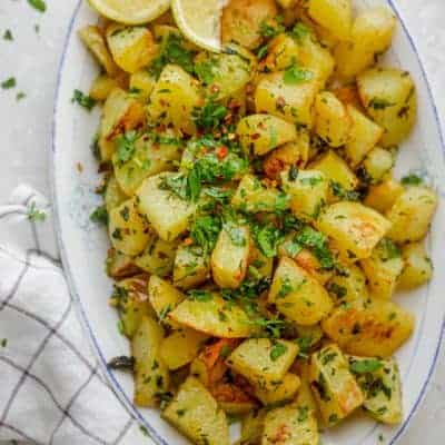 Lebanese Spicy Potatoes, also know as Batata Harra served with fresh cilantro and lemon wedges