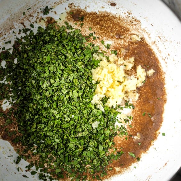 Onions, cilantro, and garlic added to the same pot once the beef is removed.
