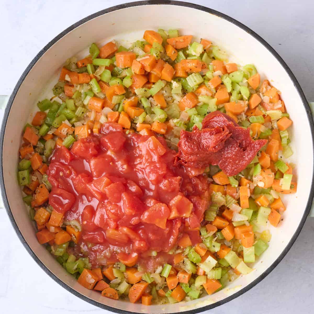 Tomato paste and diced tomatoes added to the pot.