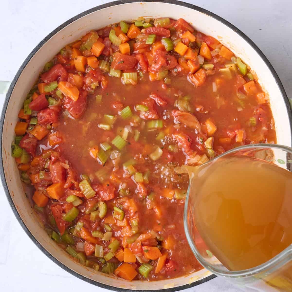 Vegetable broth being poured into the pot.