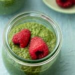 Close up shot of the pudding made with matcha tea powder topped with raspberries