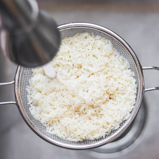 Rice in fine mesh sieve after rinsed.