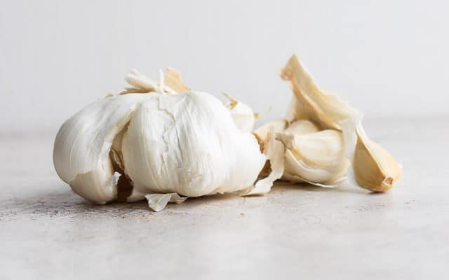 side shot of garlic and cloves
