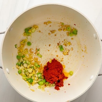Sautรฉed green onions and ginger with added garlic and red curry paste.