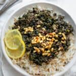 Lebanese Spinach Stew (Sabanekh wu riz) served with pine nuts and lemon slices