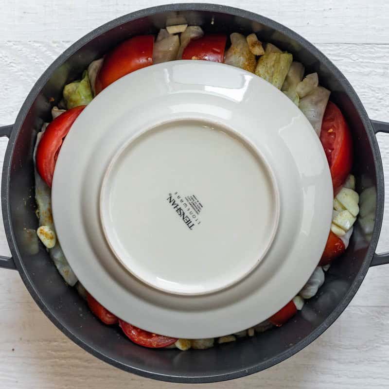 Plate face down on top of the rolls and tomatoes.