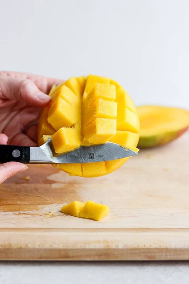 knife cutting fruit cubes