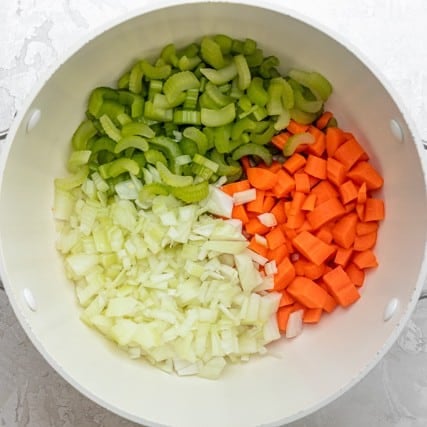 Onions, carrot and celery in a pot.