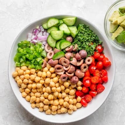 All of the salad ingredients in a bowl before mixing.