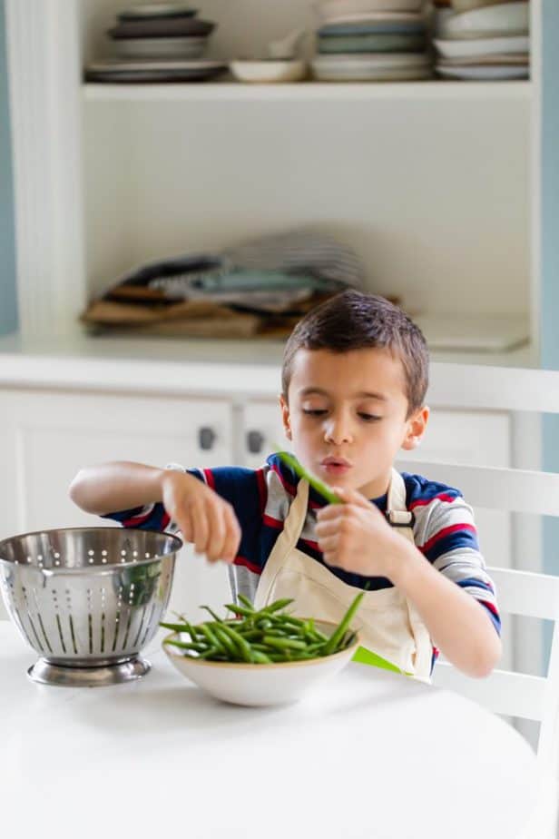 My son with bowl of green beans trimming off ends