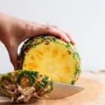 Trimming the end off a pineapple