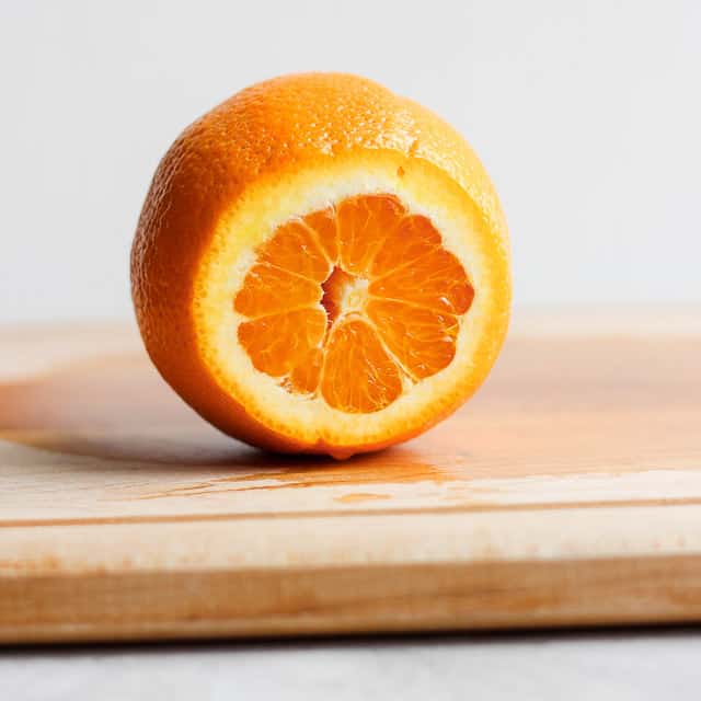 Orange on cutting board with the top sliced off