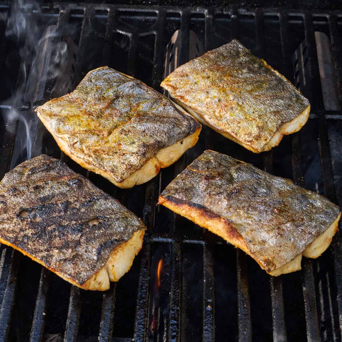 4 fillets flipped over on a grill.